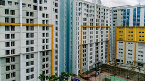 A multi-story residential building with a uniform facade, featuring a central vertical structure and balconies. - Elegant And Homey Studio At Paramount Skyline Apartment (Gading Serpong)