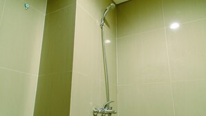 A shower with a handheld showerhead and a wall-mounted faucet. - Elegant And Homey Studio At Paramount Skyline Apartment (Gading Serpong)