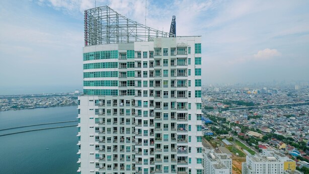 A high-rise building with a modern architectural design, featuring multiple balconies and large windows. - Comfort And Elegant 1Br Green Bay Condominium Apartment (Jakarta)