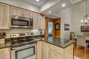 Enjoy cooking in this well-equipped kitchen with stainless steel appliances, a double oven, and a dining area.