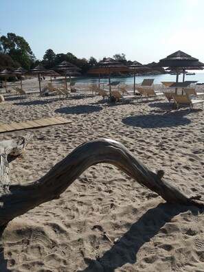A sandy beach with lounge chairs and thatched umbrellas. - Villa with private staircase feet in the water Solenzara area (Travo)