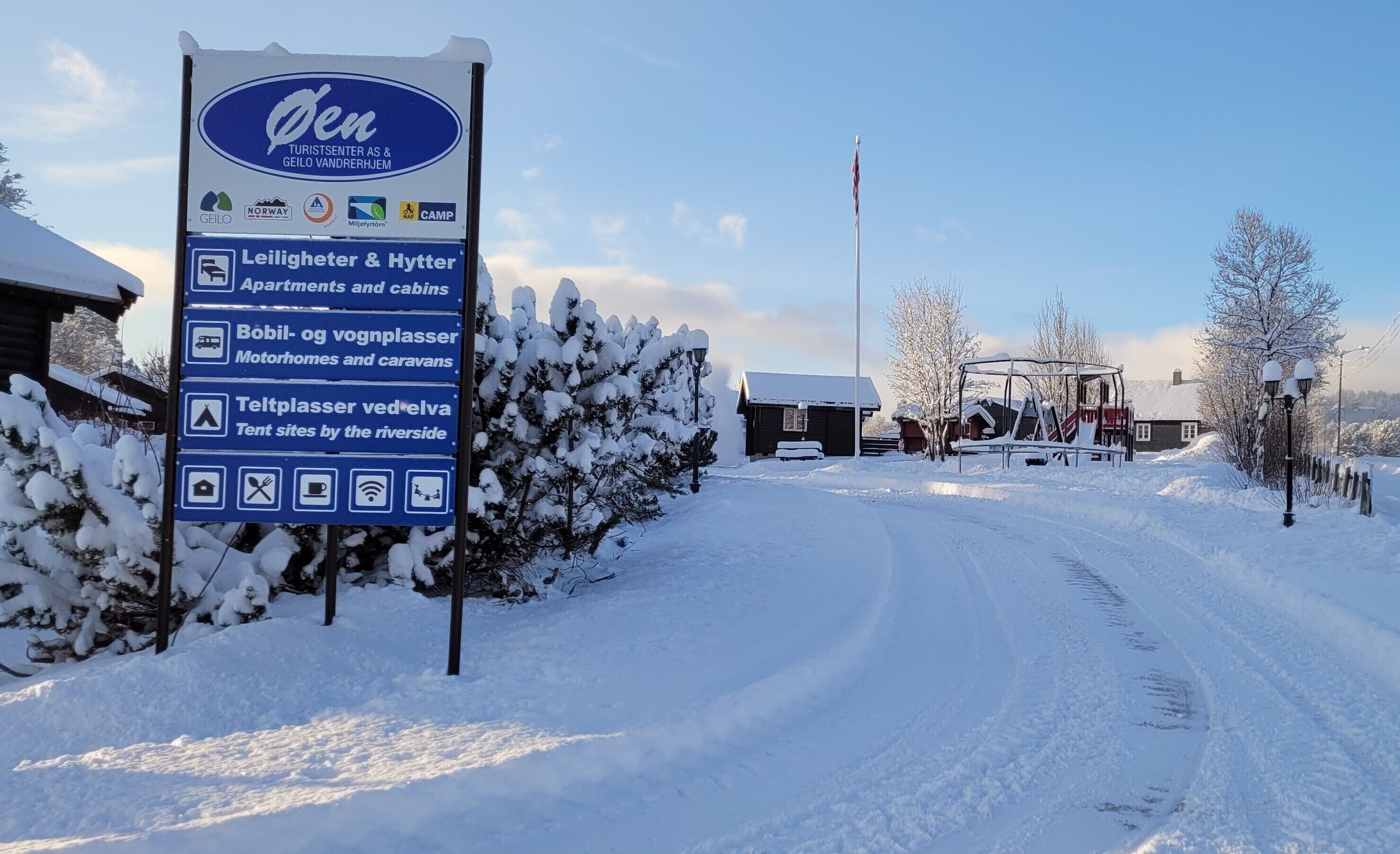 A signboard for a tourist center with amenities like accommodations, mobile homes, and tent sites.