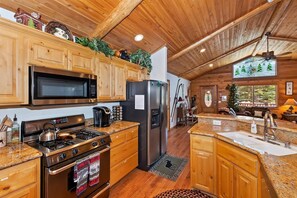 A kitchen with wooden cabinets, stainless steel appliances, and a granite countertop.