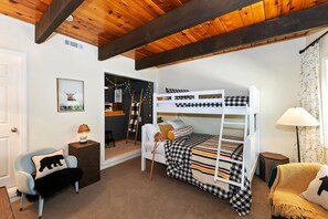 A bunk bed room with a wooden ceiling, a chair with a bear pillow, a lamp, and a small table. - Wonderful Moonridge Location! Mountain Views! Hot Tub! Pool Table! Spacious Deck! (Big Bear Lake)