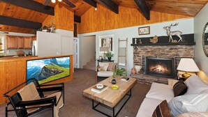 A spacious living area with a fireplace, a television, and a sofa. - Wonderful Moonridge Location! Mountain Views! Hot Tub! Pool Table! Spacious Deck! (Big Bear Lake)