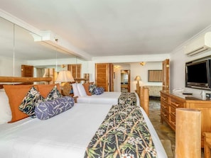A hotel room with two beds, a television, a mirror, and a wooden dresser. - 1 Bedroom Tiki Terrace Suite - Bamboo Waikīkī Hotel #903 (Honolulu)