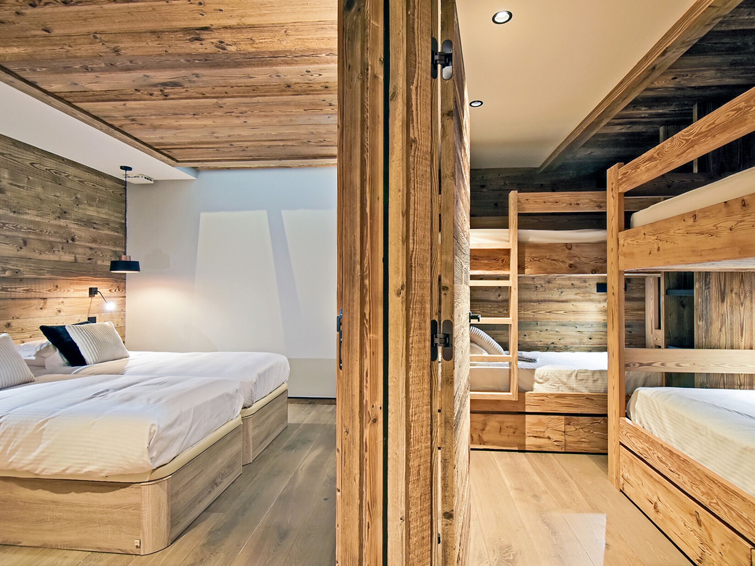 A modern bedroom with a wooden ceiling and built-in bunk beds.