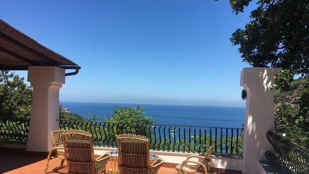A terrace with wicker chairs and a table, overlooking the ocean. - Villa Sunrise (Lacco Ameno - Forio)