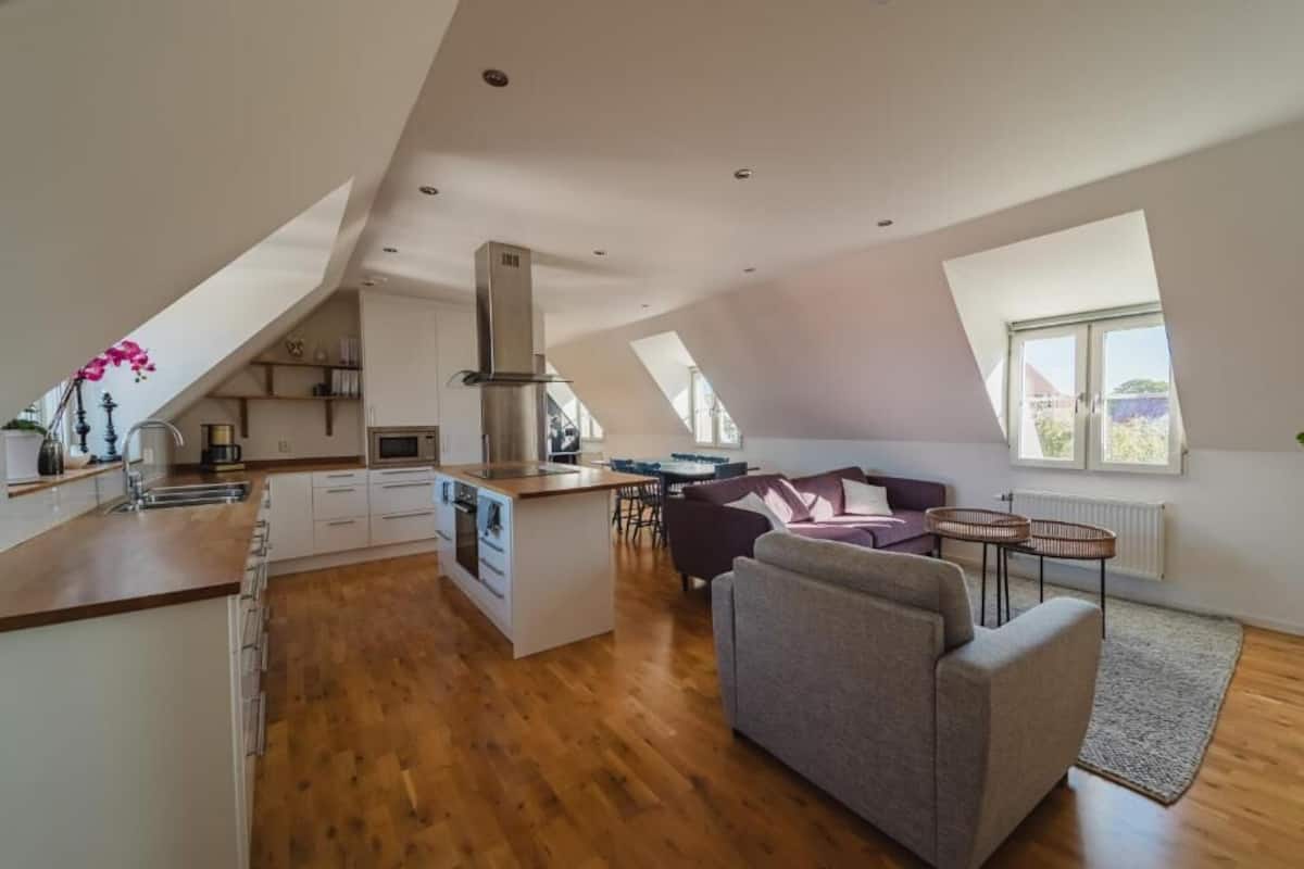Eine moderne Loftwohnung mit Küche, Essbereich und Wohnzimmer.