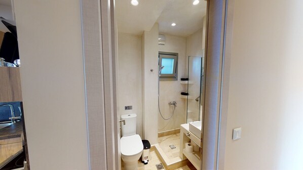 A compact bathroom with a toilet, bidet, and shower.