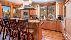 A kitchen with wooden cabinets, a granite countertop, and a view of a mountainous landscape. - Luxury Private Home In A Great Location. Hot Tub. (Breckenridge)