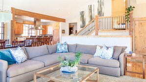 A modern living room with a sectional sofa, a glass coffee table, and a staircase leading to an upper level. - Luxury Private Home In A Great Location. Hot Tub. (Breckenridge)