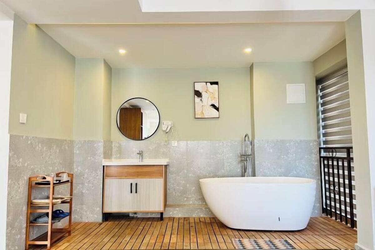Ein modernes Badezimmer mit einer freistehenden Badewanne, einem Holzwaschtisch und einem großen Spiegel.