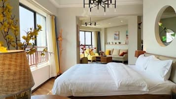 Ein Hotelzimmer mit einem großen Bett, Blick auf einen Balkon und einem modernen Kronleuchter.
