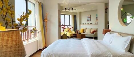 A hotel room with a large bed, a view of the balcony, and a modern chandelier.
