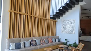 Ein modernes Wohnzimmer mit einer Couch, Sesseln und einer Treppe.