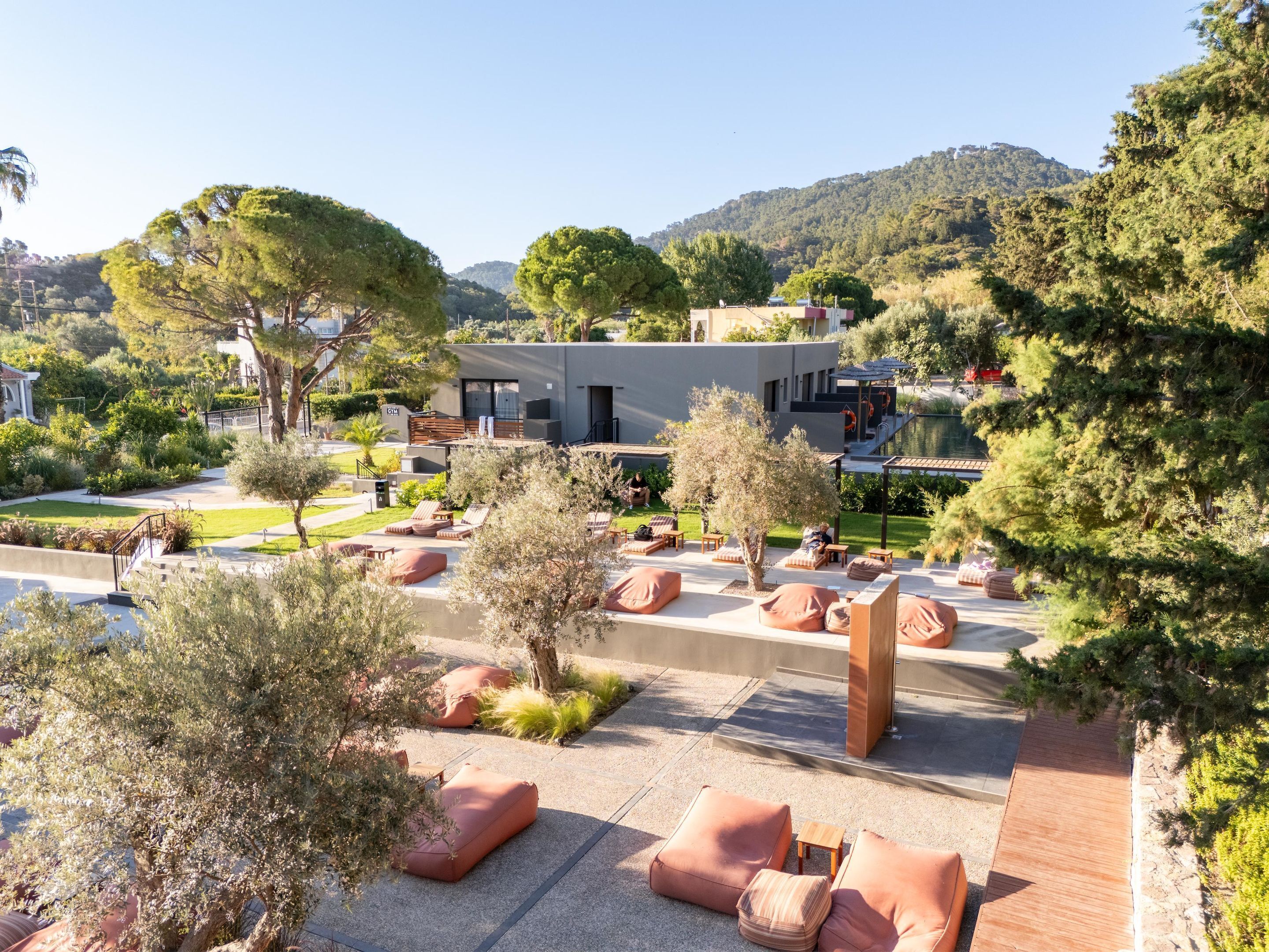 A modern building with outdoor seating areas and a pool.