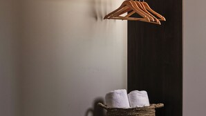 Eine dunkle Holzbank mit einem gewebten Korb, der zwei Handtücher enthält.
