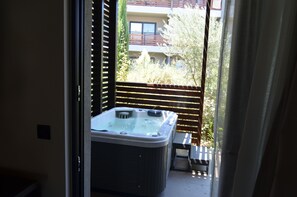 A hot tub in a balcony area with a view of a building and trees. - Cook's Club Ialysos Rhodes (Rhodes)