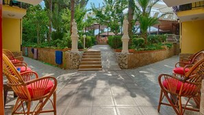 A courtyard with a central staircase, surrounded by chairs and potted plants. - GARDEN RUYA HOTEL (Fethiye)