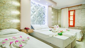 A hotel room with two beds, a decorative wall panel, a red-framed window, and a wooden nightstand with a telephone. - GARDEN RUYA HOTEL (Fethiye)