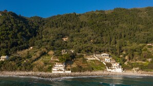 Une zone côtière avec des bâtiments construits sur une colline, un littoral rocheux et une vue dégagée sur la mer.