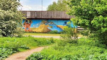 A mural on a wooden structure with greenery in the foreground.