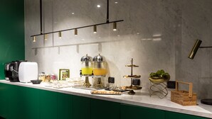 Una encimera de cocina moderna con una cafetera, un dispensador de zumo y diversos alimentos.
