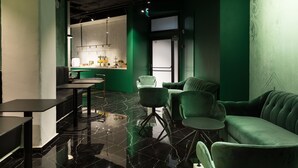 Un interior moderno con un sofá verde, un comedor y una cocina.