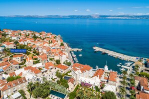 Une ville côtière aux bâtiments aux toits rouges, dotée d’un port de plaisance et d’une église imposante.