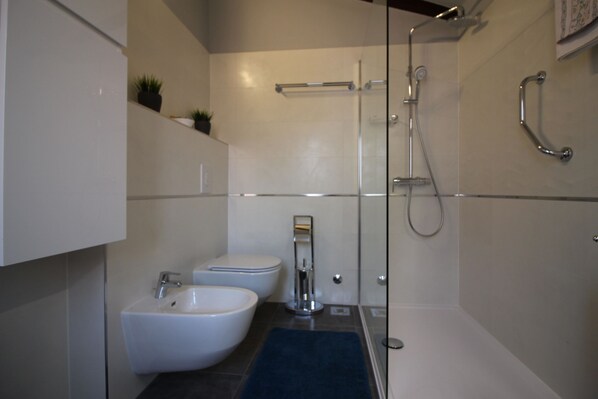 A modern bathroom with a glass-enclosed shower, a bidet, and a sink. - Near the beach, City center, Air-conditioned, Quiet location, Family-friendly (Poreč)