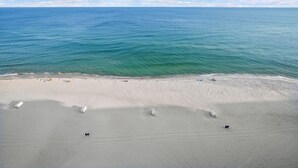 Une plage à l’eau turquoise et au sable blanc.