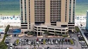 Un hôtel à plusieurs étages doté d’une cour intérieure, d’un parking et offrant une vue sur la plage.