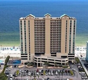Un hôtel à plusieurs étages doté d’une cour intérieure, d’un parking et offrant une vue sur la plage.