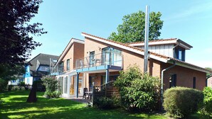 A two-story house with a balcony, a covered patio, and a well-maintained garden. - Quietly situated apartment for max. 4 persons, balcony, garden, WLAN, washing machine (Prerow)