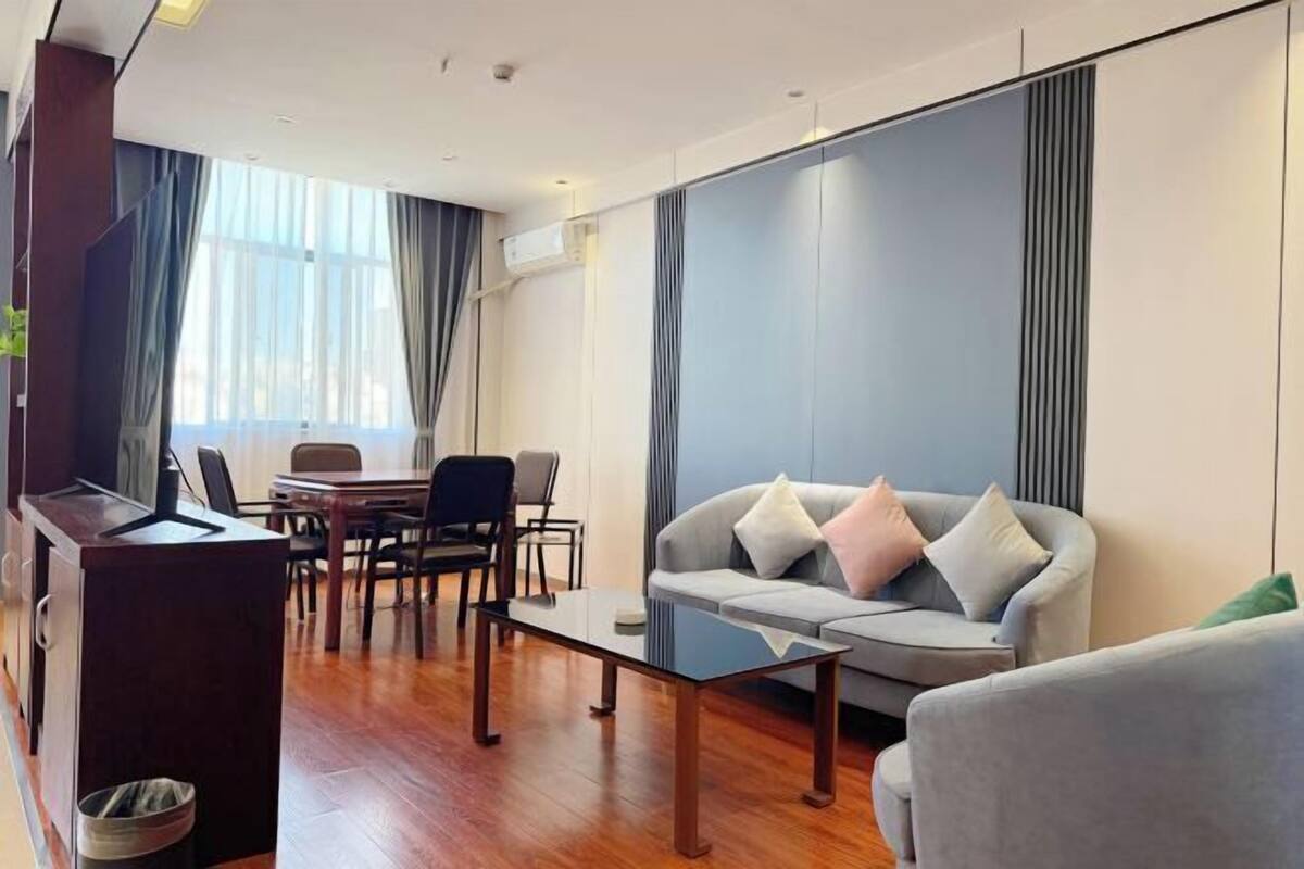 Un salon moderne comprenant un canapé, une table basse et un coin repas avec des chaises et une table.