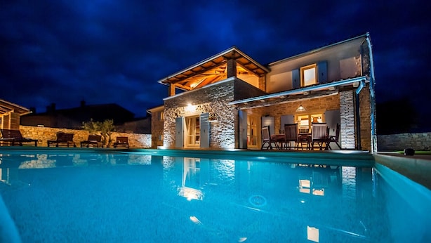 A two-story house with a swimming pool, stone facade, and outdoor seating area. - Charming Villa Tomani with pool and jacuzzi (Krmed)