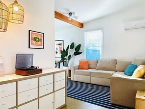 Relax in this stylish living room with a sofa, cabinet, and potted plant.