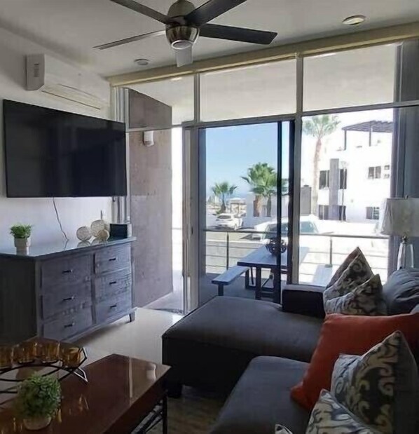 Un salon moderne avec un téléviseur à écran plat, un canapé et une table basse.