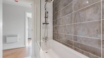 Bathtub, hair dryer, towels, shampoo