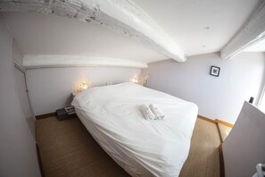 Une chambre à coucher avec un grand lit, deux lampes de chevet et un tableau encadré au mur.