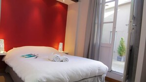 Une chambre d’hôtel avec un lit, une table de chevet, une lampe et une vue sur l’extérieur.