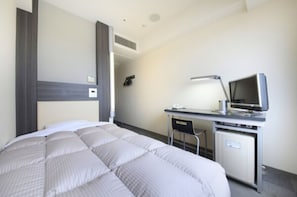 Relax in a cozy space with a neatly made bed and a convenient desk area featuring a TV and chair.