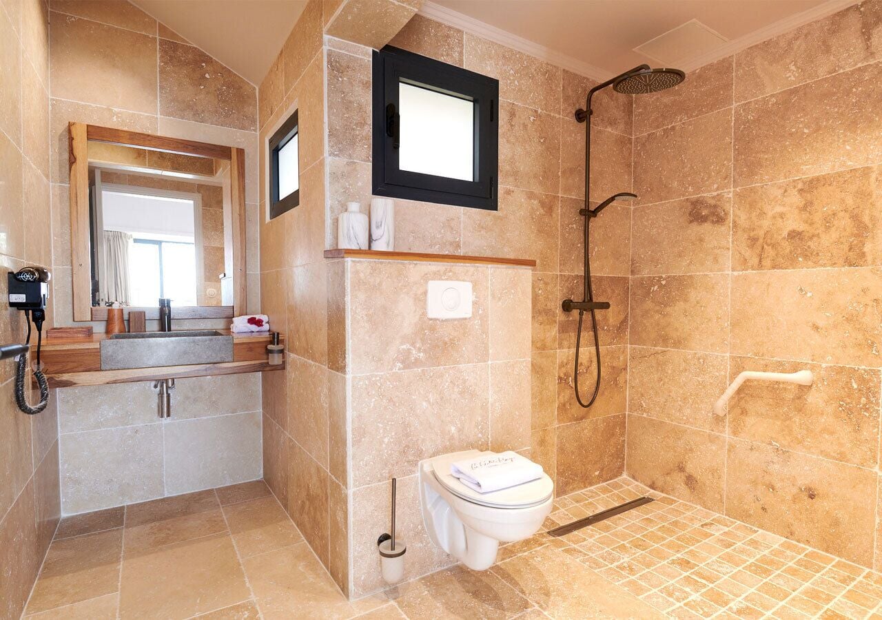 Un baño con ducha, inodoro, lavabo y espejo.