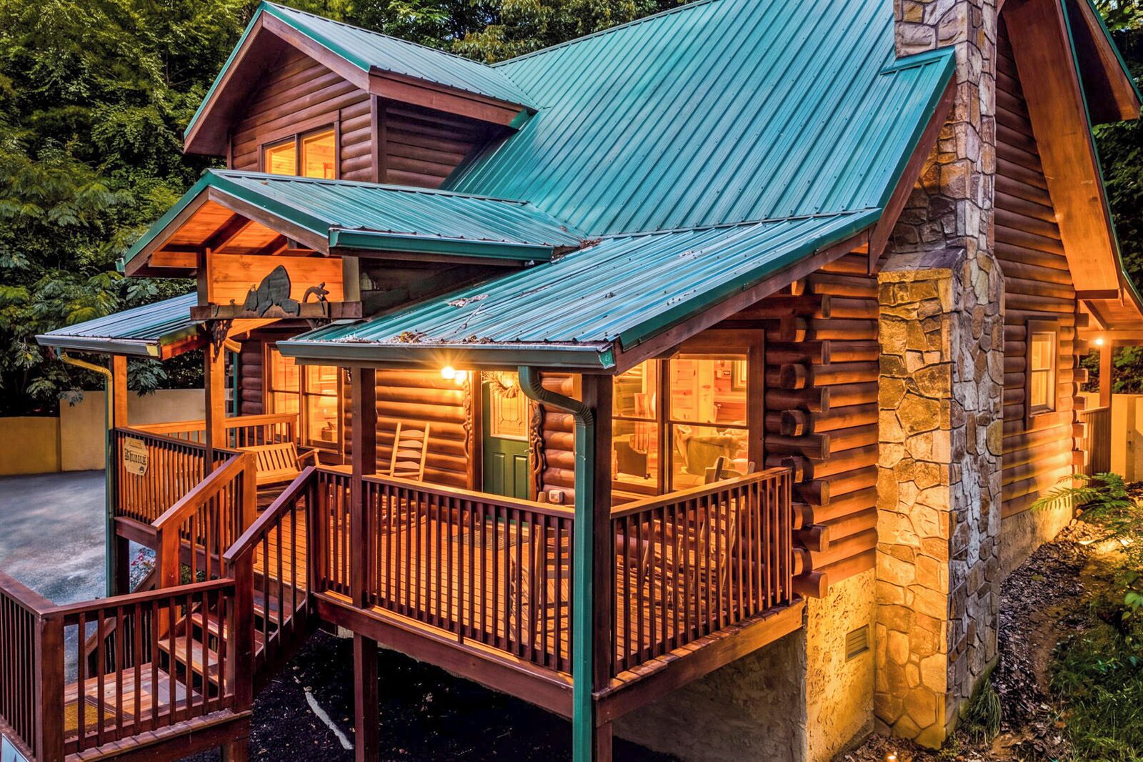 A log cabin with a porch and a stone chimney.