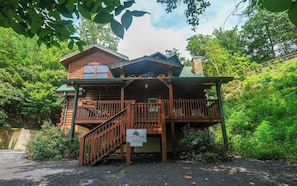 Rustic cabin-style building with a two-story design and balcony seating area.