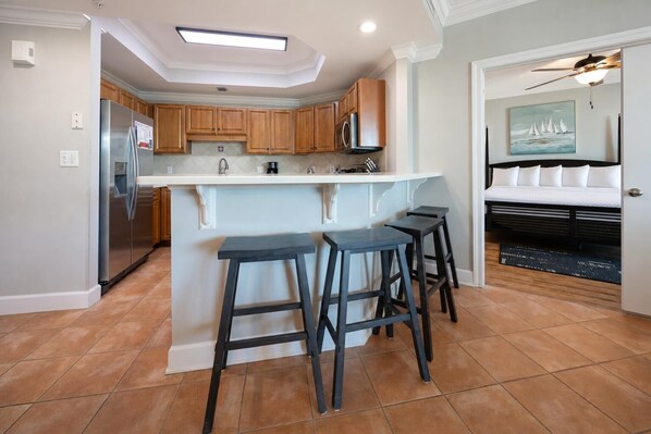 Una cocina con isla central, armarios de madera y un refrigerador.