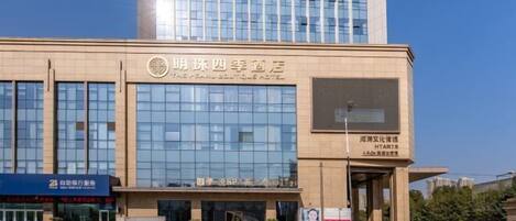 A hotel with a modern glass facade and a sign indicating it is the "Pearl Boutique Hotel."