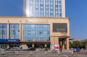 Un hotel con fachada de vidrio moderna y un cartel que indica que es el Pearl Boutique Hotel.
