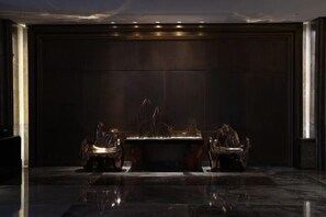 A dark room with a central table and two chairs.